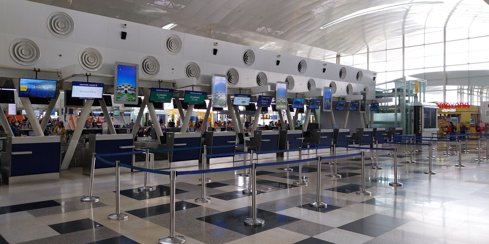 Travellers queueing at an airline check-in counter with documents ready