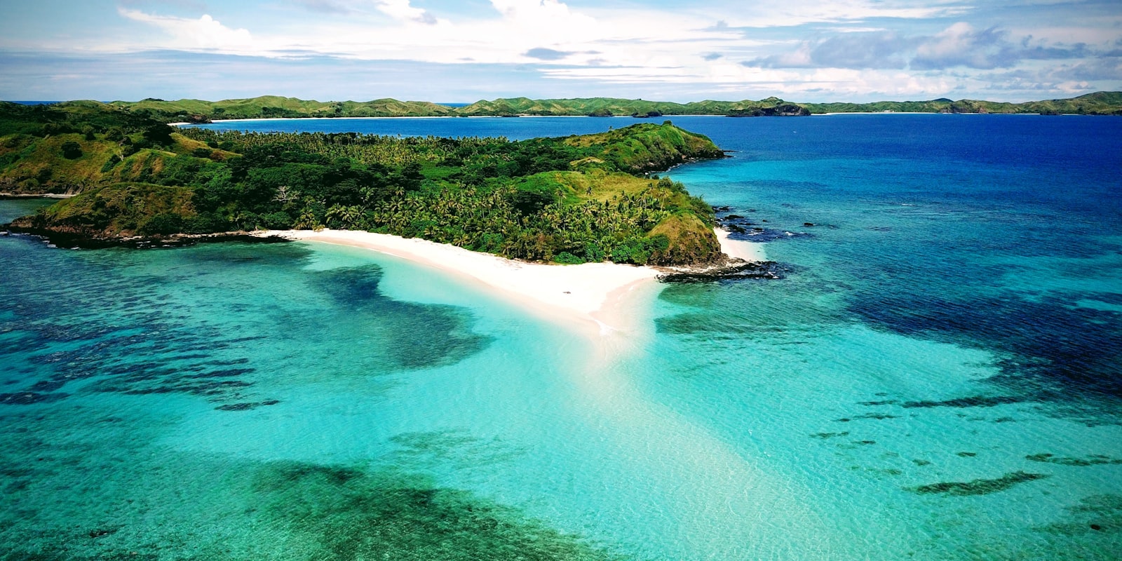 Palm-fringed beach and turquoise lagoon in the Mamanuca Islands, Fiji