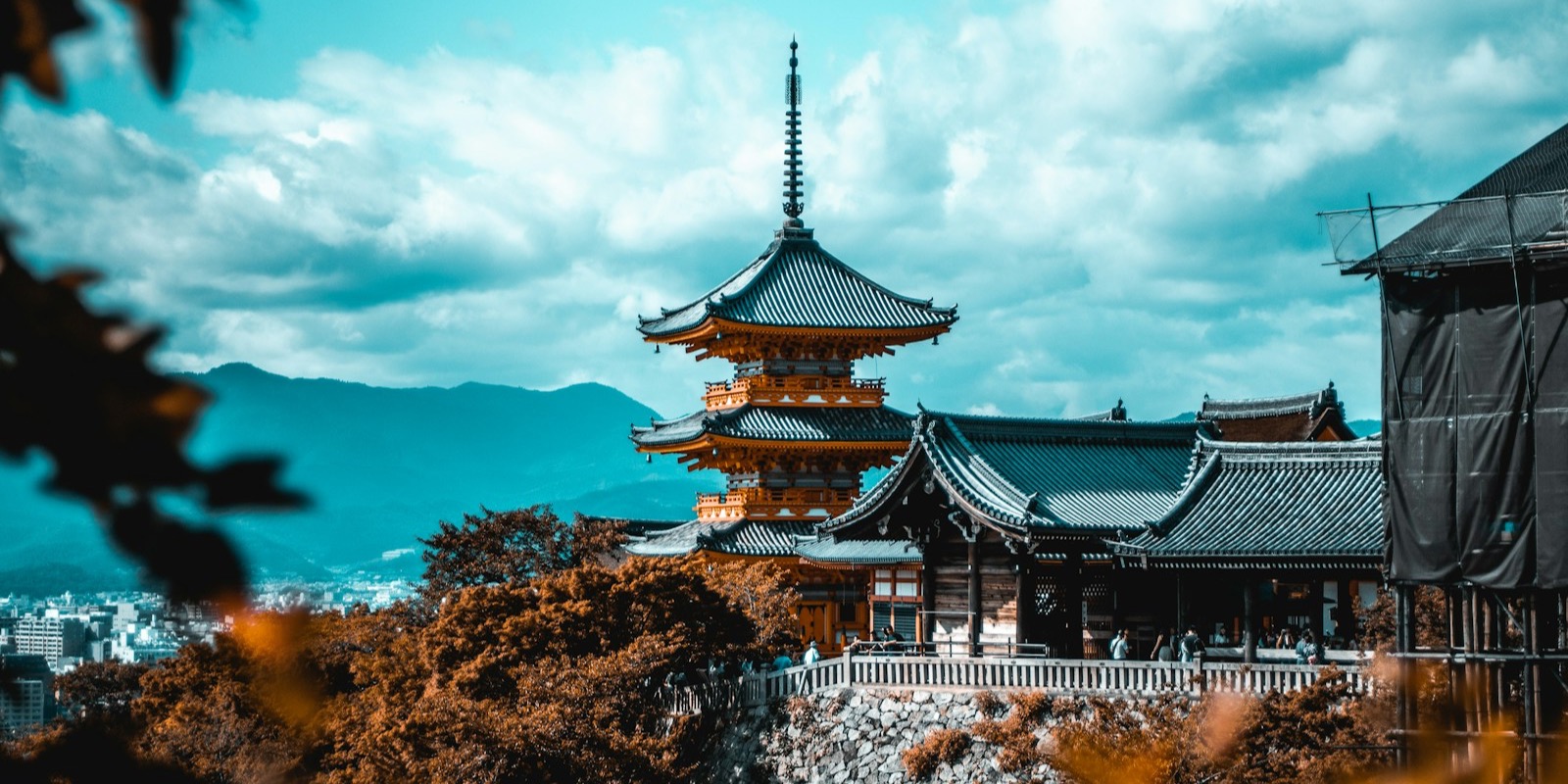 A traditional Japanese pagoda among trees under a blue sky