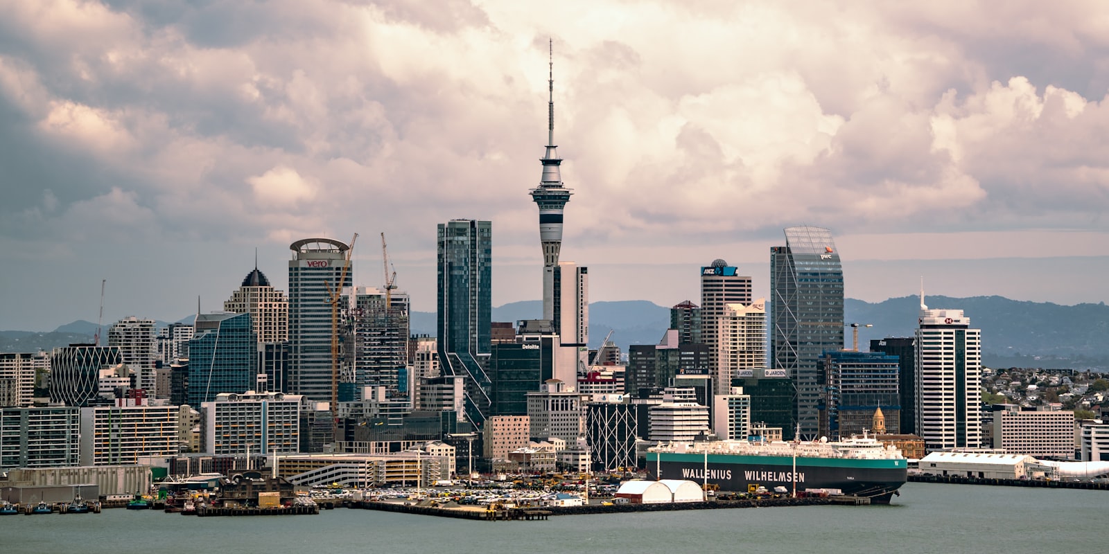 Auckland harbour at golden hour with the Sky Tower rising over the waterfront