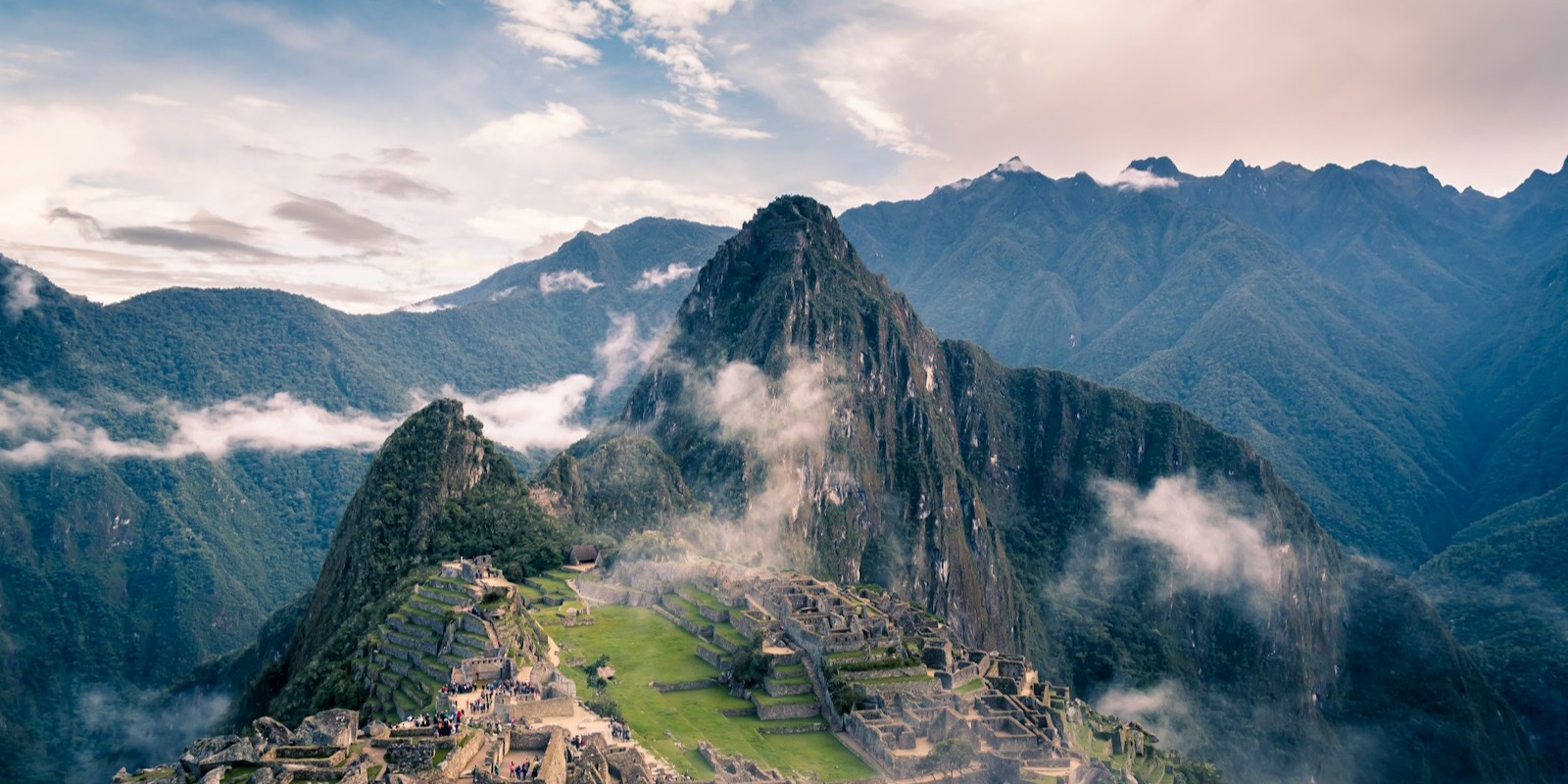 Sunrise over Machu Picchu with mist rising through the Andes, a classic first view for travellers arriving in Peru