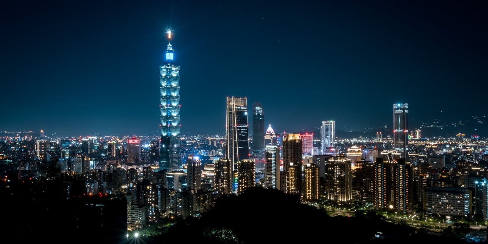 Taipei city skyline at dusk with Taipei 101 rising above the surrounding streets