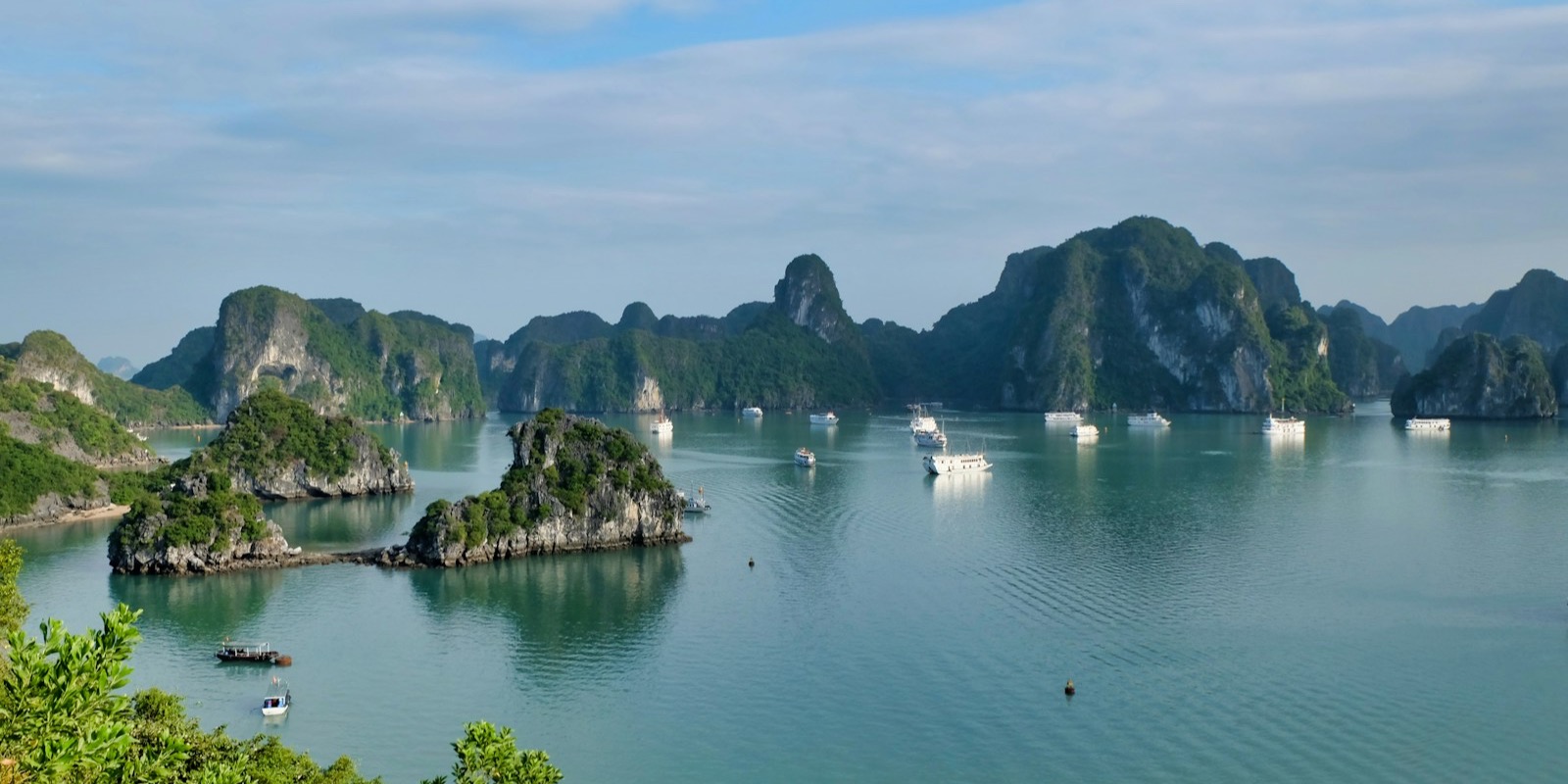 Limestone karsts rising from the calm water of Ha Long Bay, Vietnam