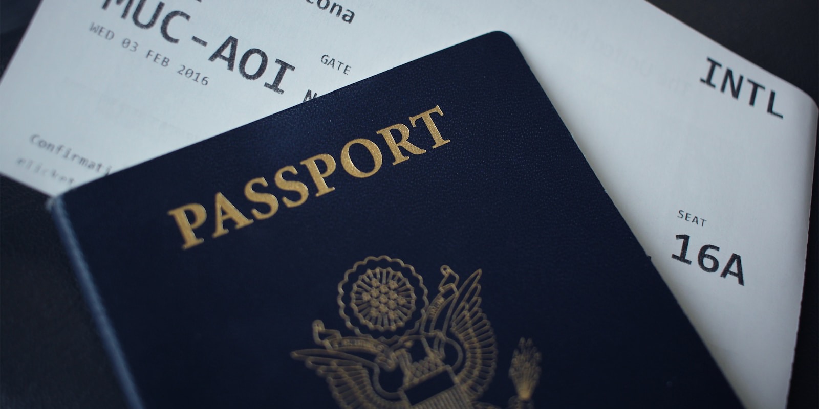 A traveller filling in a visa application at a desk with a passport and laptop
